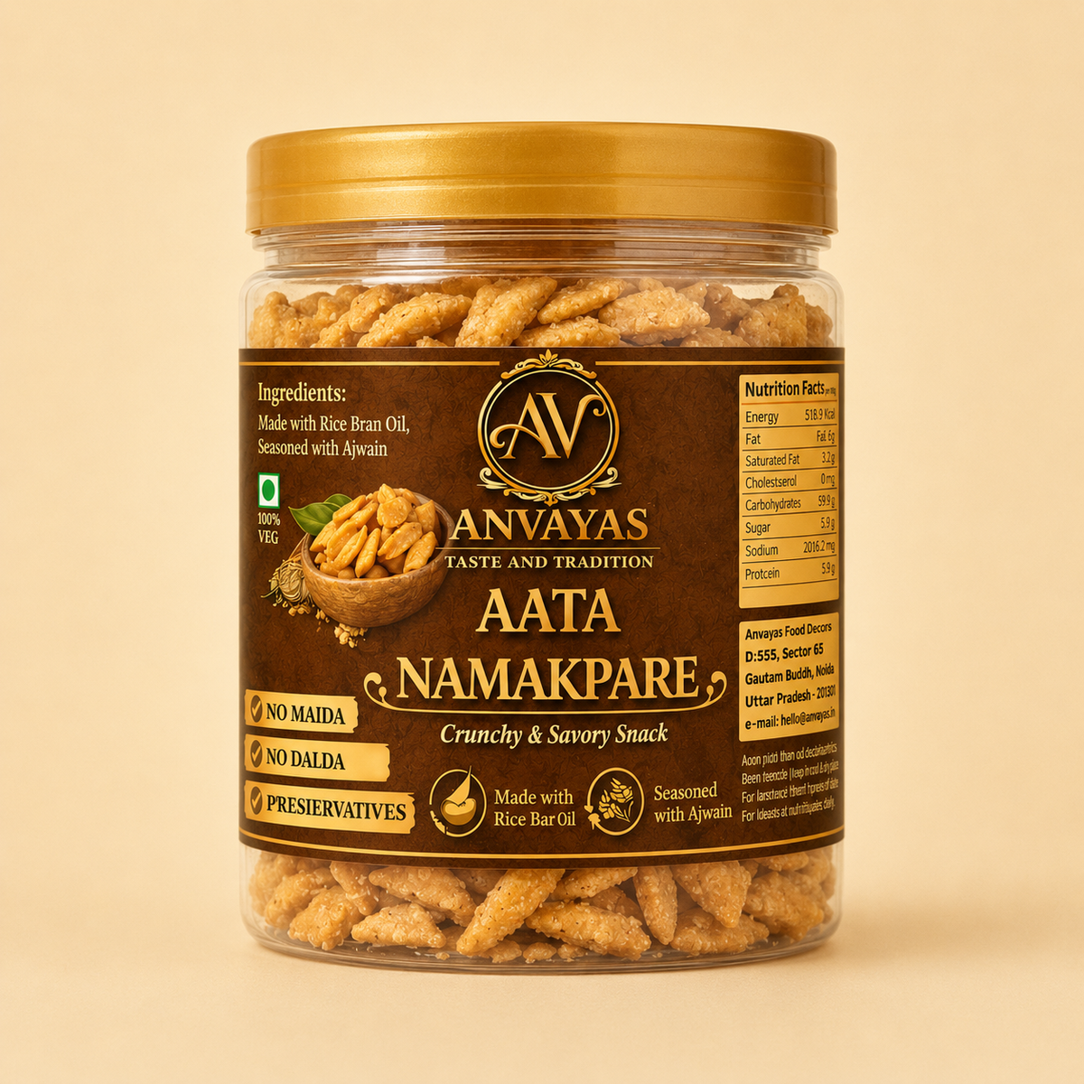 A jar of Anvayas Aata Namakpare crunchy and savory snack, featuring a gold lid and a dark brown label with product details, set against a solid beige background.