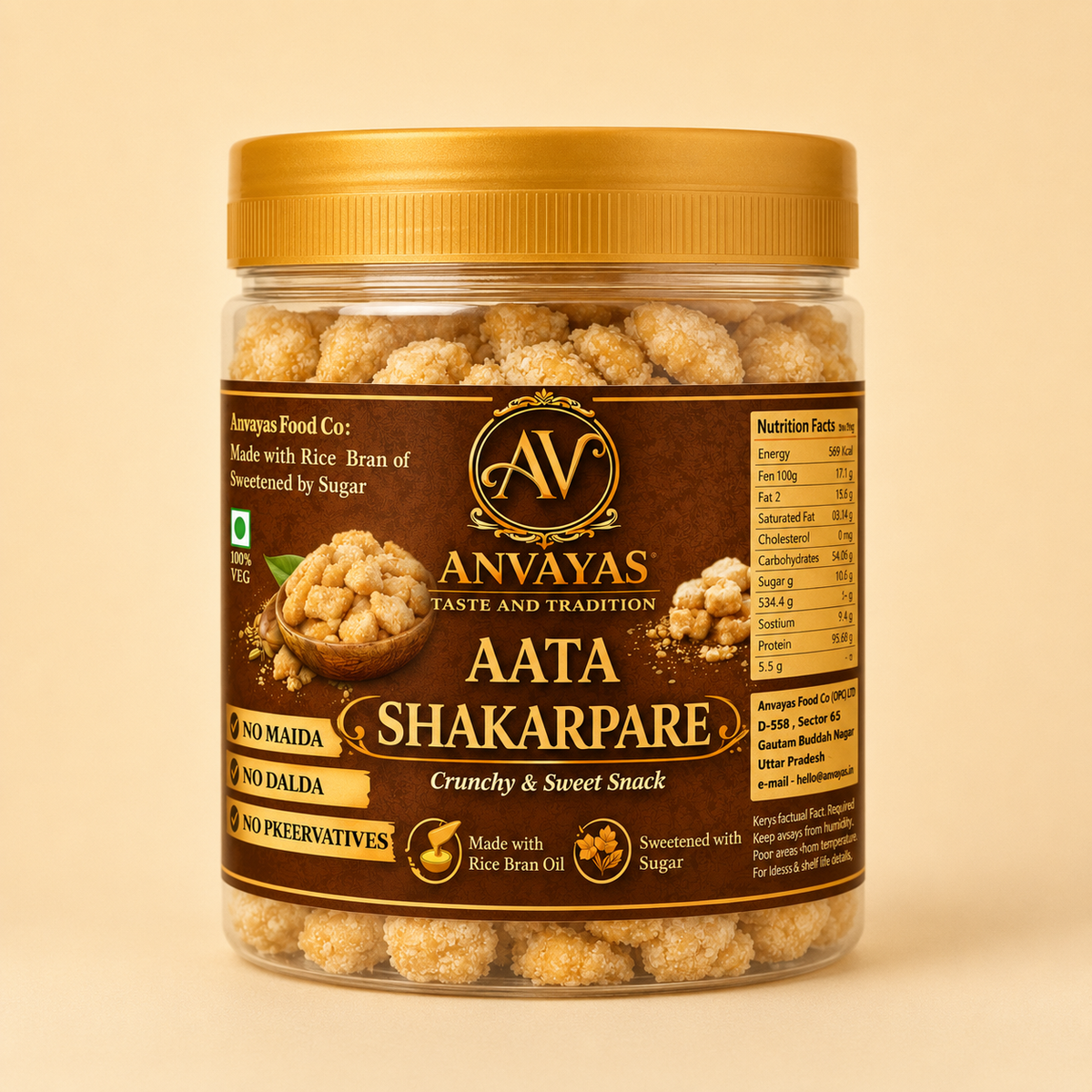 A jar of Anvayas Aata Shakarpare crunchy and sweet snack, featuring a gold lid and a dark brown label with gold and white text, set against a solid beige background.